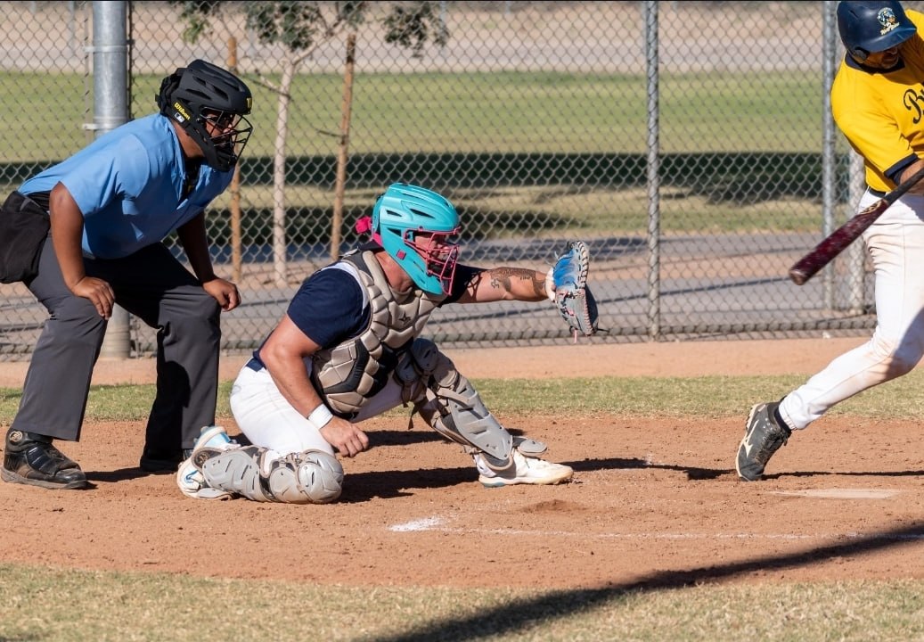 Coach Crosby catching live behind home plate, mitt extended